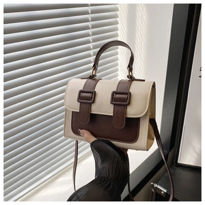 Close-up of contrast color handbag with high quality leather texture and buckle detail