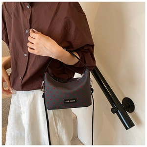 Sac bandoulière tendance en toile gris foncé avec motif cœur porté par un mannequin