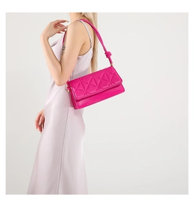 Detail of fuchsia quilted shoulder bag with triangular texture and knotted strap detail