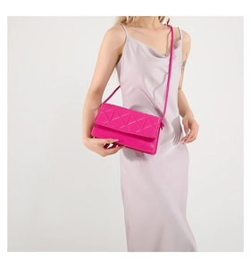 Detail of rose pink quilted crossbody bag with golden hardware and leather strap