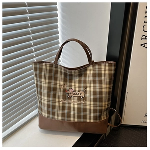 Gros plan du sac cabas vintage à carreaux avec broderie détaillée de teckel sur tissu