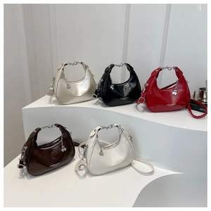 Minimalist crescent handbags in five colors on a sleek white display stand for women