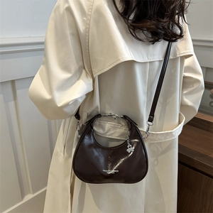 Fashionable brown leather crescent hobo bag for women with silver clover charm pendant