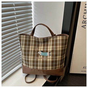Détail du sac seau à carreaux avec broderie chien et base en cuir marron de qualité