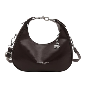 Minimalist deep brown crescent shoulder bag in vintage leather with metal heart charm
