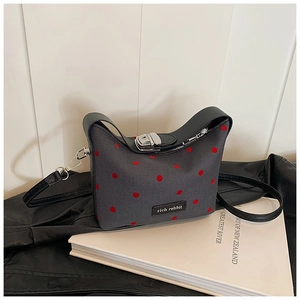 Détail du sac à main gris à pois avec fermoir argenté et plaque logo rich rabbit