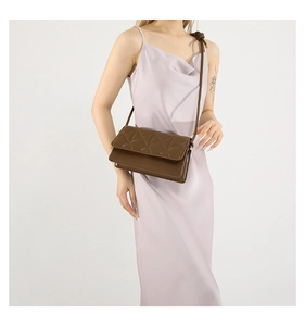 Close-up of coffee brown quilted leather shoulder bag with fine geometric stitching details