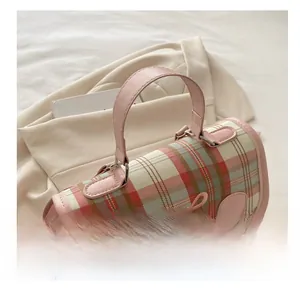 Detail van roze geruite handtas met strikdecoratie en vintage metalen gesp