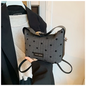Détail du sac à main gris à chevrons avec pois noirs et logo de marque Rich Rabbit