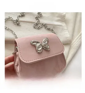 Gros plan du mini sac carré rose avec fermoir papillon en métal argenté et bandoulière