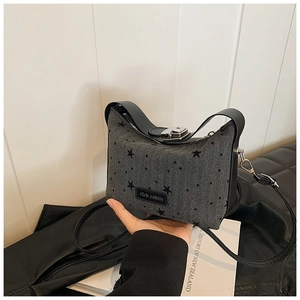Détail du sac à main gris en tissu à chevrons avec imprimé étoile et étiquette cuir