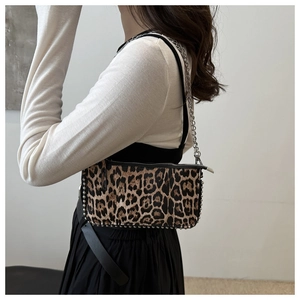 Détail du sac sous l'aisselle à imprimé léopard avec clous et chaîne en métal