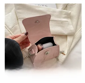 Vue détaillée de la capacité interne et du fermoir magnétique du mini sac carré rose à chaîne