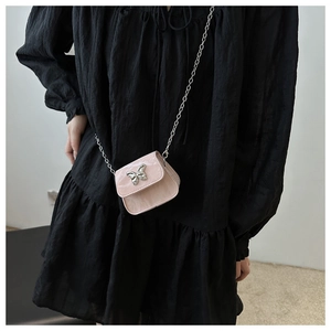 Vue détaillée du micro-sac rose avec boucle nœud métallique et chaîne argentée