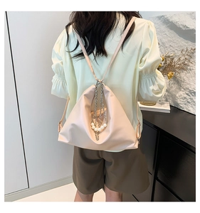 Detail of light pink soft leather tote bag with silver chains and white pearls