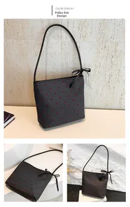 Dettaglio della borsa a tracolla in tela a pois con fiocco nero decorativo