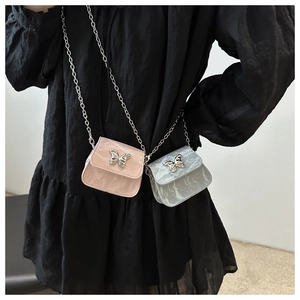 Détail de mini sacs carrés en rose et argent avec nœuds texturés et finitions métalliques