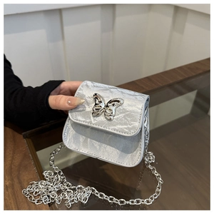 Gros plan du mini sac à chaîne gris argenté avec texture plissée métallique et papillon chic