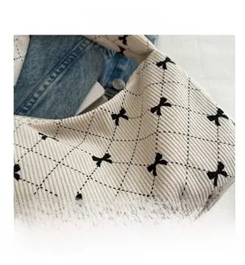 Détail du sac bandoulière en velours côtelé avec surpiqûres losanges et motifs nœuds