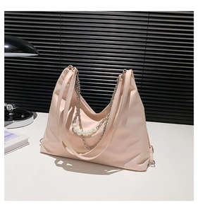 Detail of light pink tote bag with silver chain and five large white pearls decoration