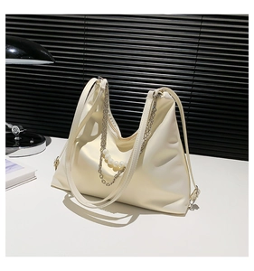 Close-up of cream PU leather tote bag with elegant pearl and metal chain decoration