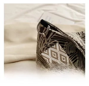 Detail of vintage geometric jacquard strap with silver metal hook on a woven tote bag