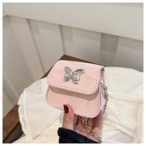 Détail d'un mini sac à bandoulière rose avec fermoir papillon argenté et fine chaîne argent