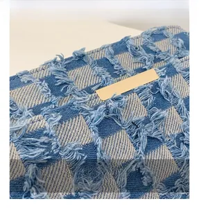 Detailed macro shot of blue and white checkered denim fabric with gold hardware