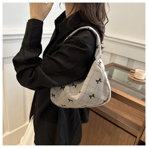 Détail du sac hobo en velours côtelé avec motif de losanges noirs et imprimés de nœuds