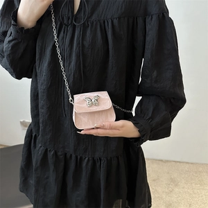 Mini sac bandoulière rose marbré avec boucle papillon argentée et chaîne en métal