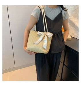 Détail du sac cabas en paille tissé main avec anses en corde blanche et nœud en soie