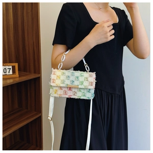 Detail shot of colorful tweed crossbody bag with white chain handle and woven texture