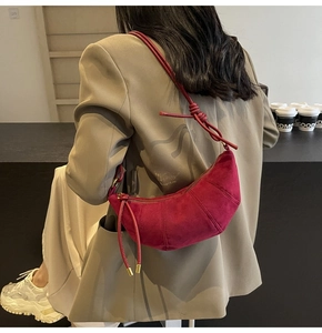 Detailaufnahme einer burgunderroten Wildledertasche mit Knotengurt und Nähten