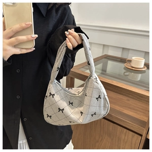 Vue détaillée du sac hobo en velours côtelé gris clair avec motif matelassé et nœuds