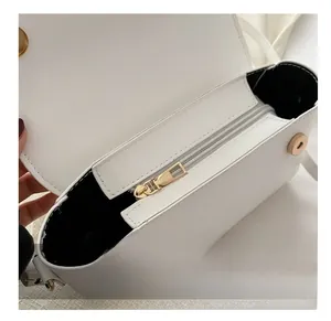 Close-up of white leather handbag interior showing smooth zipper and magnetic closure