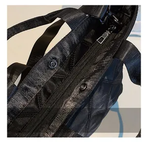 Detailed macro view of the smooth metal zipper and quilted diamond pattern on the nylon tote
