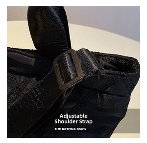 Detail view of the adjustable shoulder strap on a black quilted rhombus nylon bucket bag