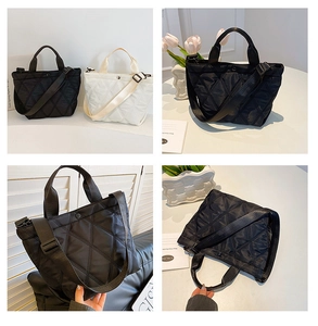 Detail view of quilted nylon bucket bag in black and beige showing stitching and strap