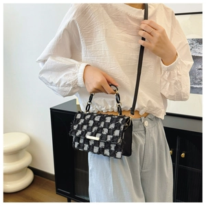 Detail of tweed crossbody bag with black and white checkerboard texture and chain