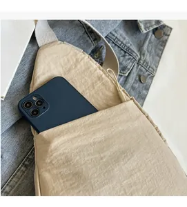 Détail du sac de poitrine kaki avec poche avant pratique pour ranger un smartphone
