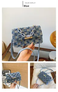 Detail of blue denim patchwork crossbody bag with fringe edges and acrylic chain