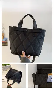 Detailed view of black quilted nylon tote bag with polished finish and top handles