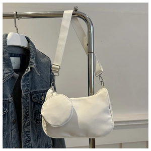 Nahaufnahme der weißen Nylon-Achseltasche mit kleinem Rundbeutel und Silberbeschlag