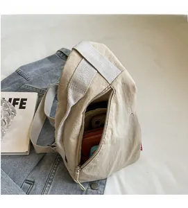Intérieur spacieux du sac bandoulière en nylon beige montrant le rangement du téléphone