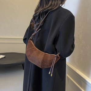 Braune Wildleder-Halbmondtasche mit verstellbarem Riemen am schwarzen Wollmantel