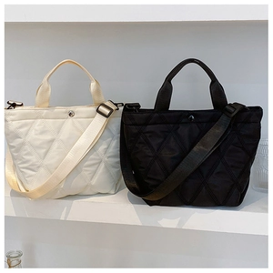 Detail view of black and beige quilted nylon bucket bags with adjustable shoulder straps