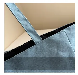 Gedetailleerd stikwerk van de blauwe denimstof en handvataansluiting op deze grote shopper
