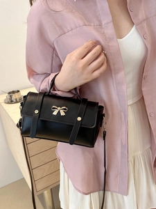 Fashionable black crossbody bag for women with gold bow detail and top handle design