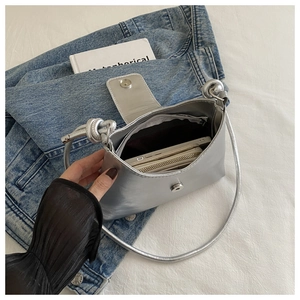 Detail showing inner zipper pocket and capacity of silver metallic shoulder bag