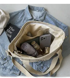 Detail view of the large capacity interior of a beige canvas tote bag with organized pockets